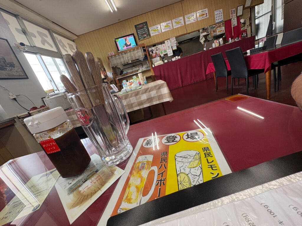 県民ステーキ 糸満店内のテーブル席とオリジナルソース