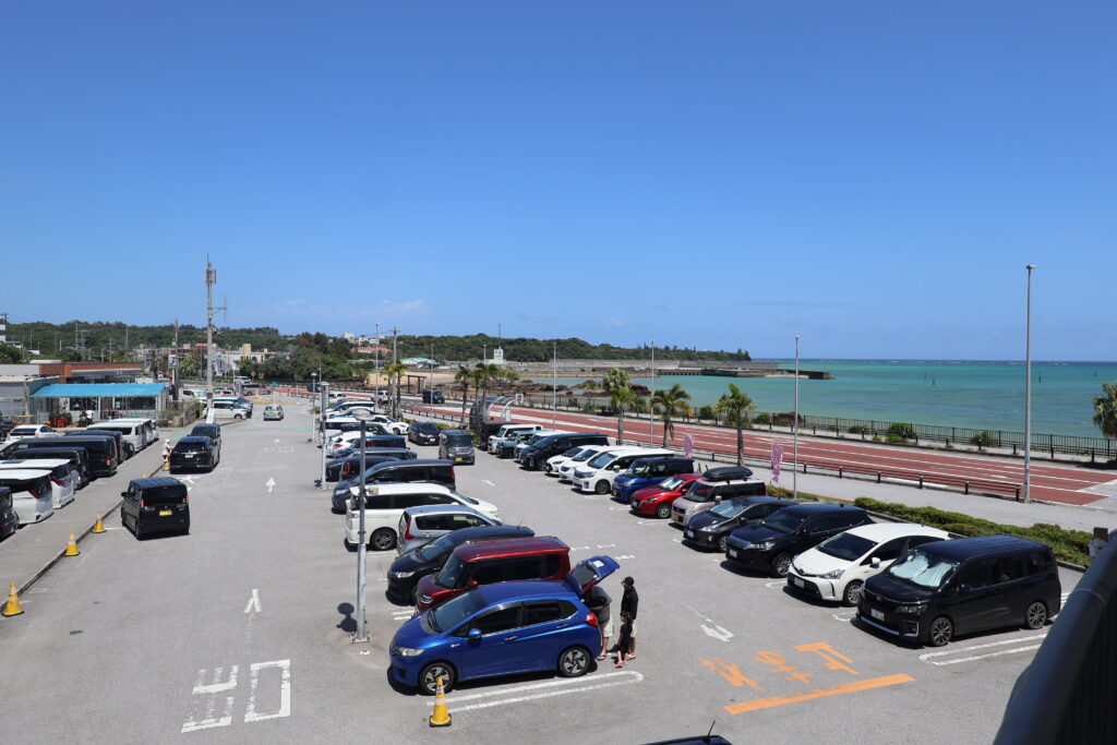 道の駅ぎのざ 広い駐車場とエメラルドグリーンの海