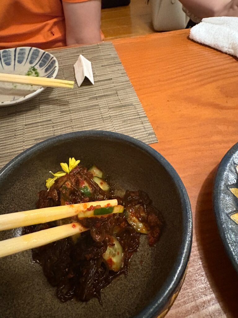喜作 もずくキムチを箸で持ち上げる