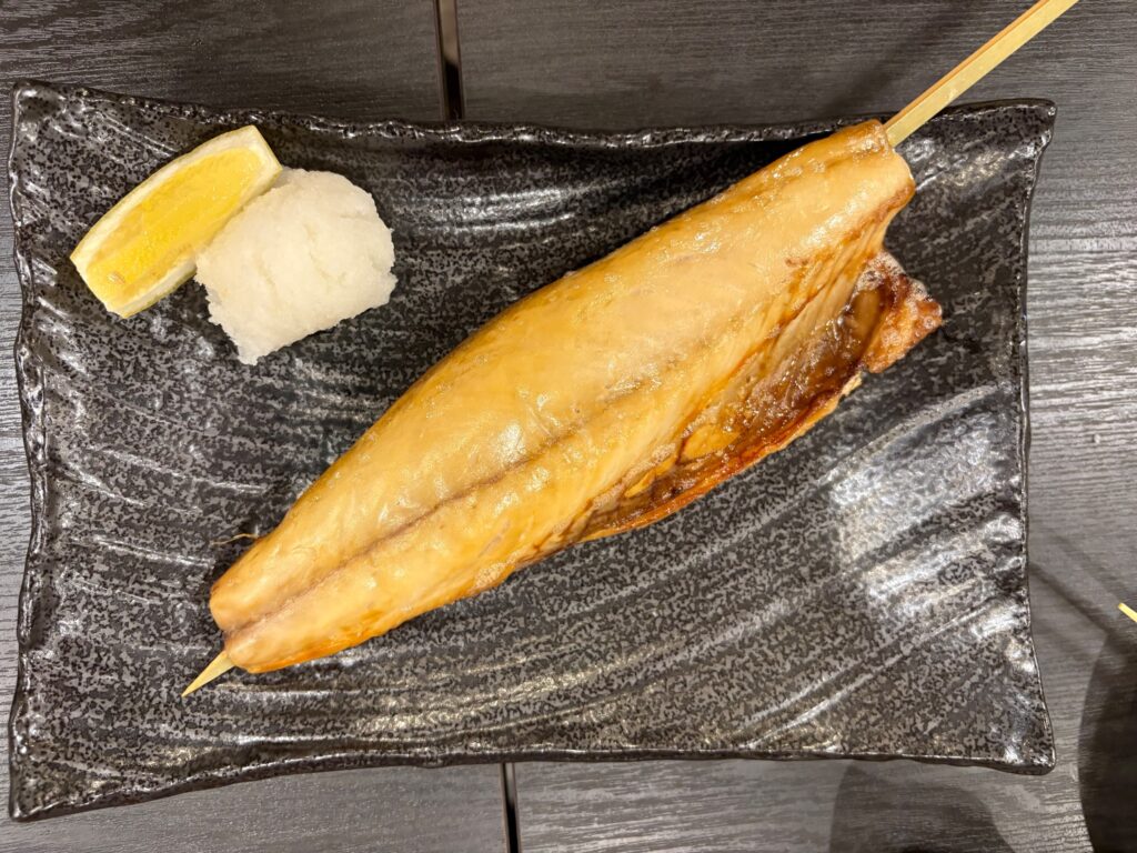 炭火で焼かれた魚の串焼き
