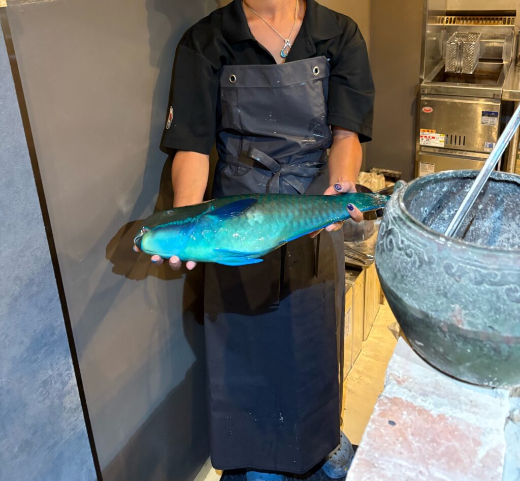 鮮度抜群の魚を持つスタッフ